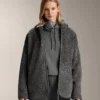 Giacca oversize in finta pelle di montone con cappuccio foderato in pelliccia sintetica Giacca oversize in finta pelle di montone con cappuccio foderato in pelliccia sintetica