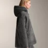 Giacca oversize in finta pelle di montone con cappuccio foderato in pelliccia sintetica Giacca oversize in finta pelle di montone con cappuccio foderato in pelliccia sintetica